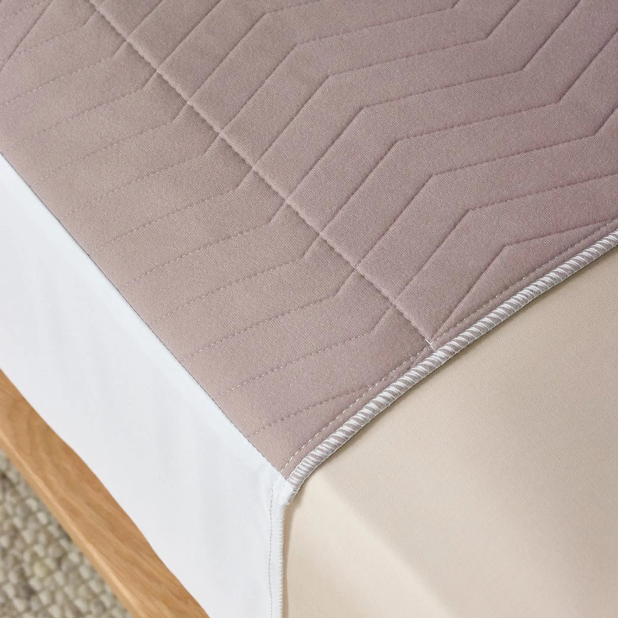 Close-up of the Clay Waterproof Bed Pad, referred to by some as Kylie bed pad in warm neutral tones, featuring a soft, quilted design for extra comfort. This reusable and washable bed pad provides incontinence protection with high absorbency and a waterproof backing to keep mattresses dry.