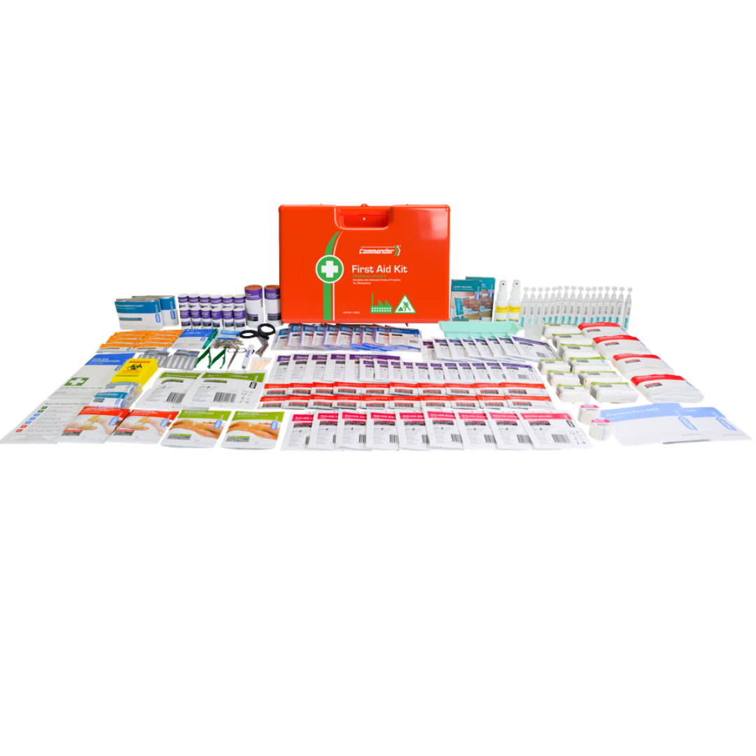 All contents of the Commander First Aid Kit laid out on a surface, with the orange case centered in the background.