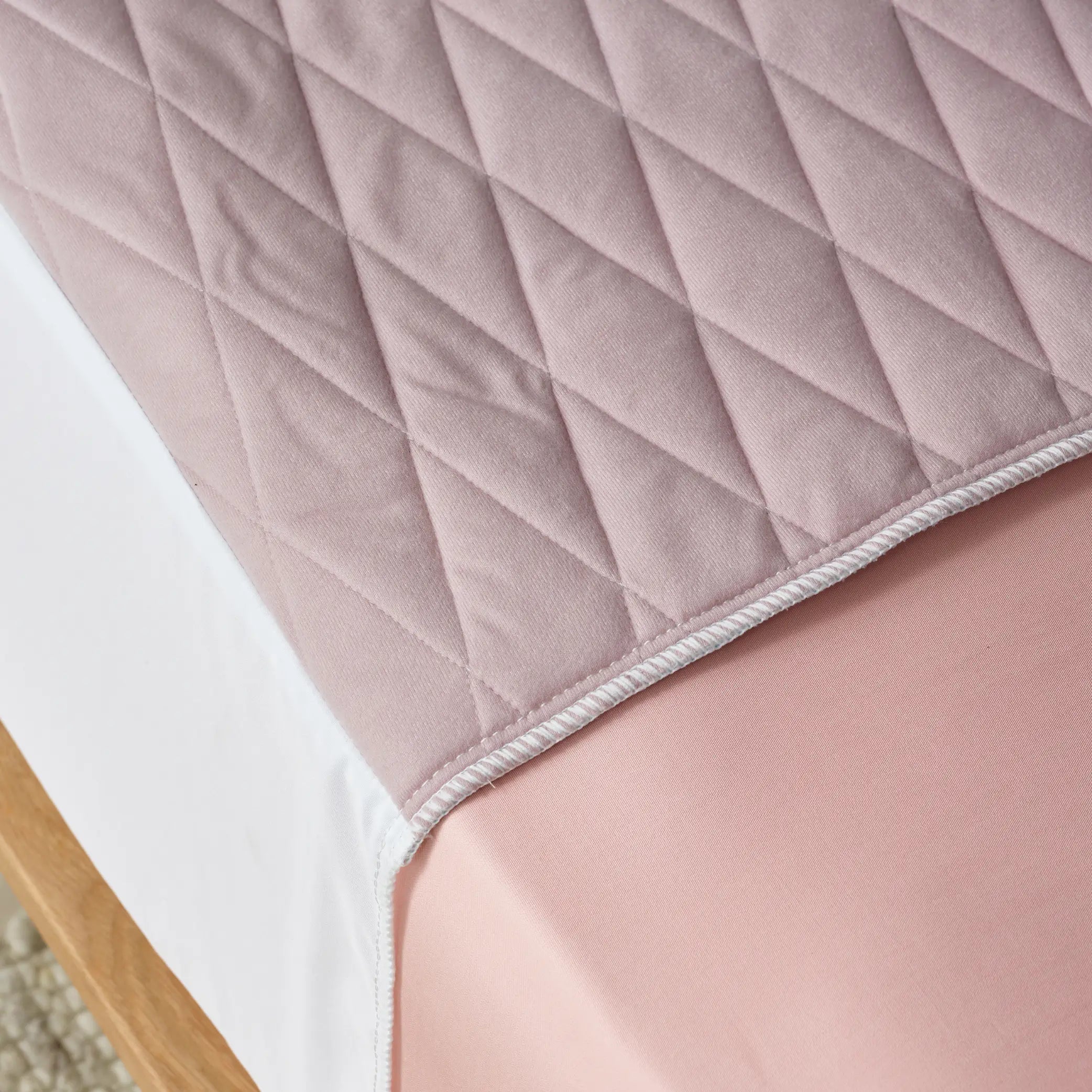 Close-up of a lilac waterproof bed pad, also called kylie bed pad with a quilted, soft-touch surface. This incontinence bed protector is absorbent, washable, and designed to keep bedding dry and comfortable.