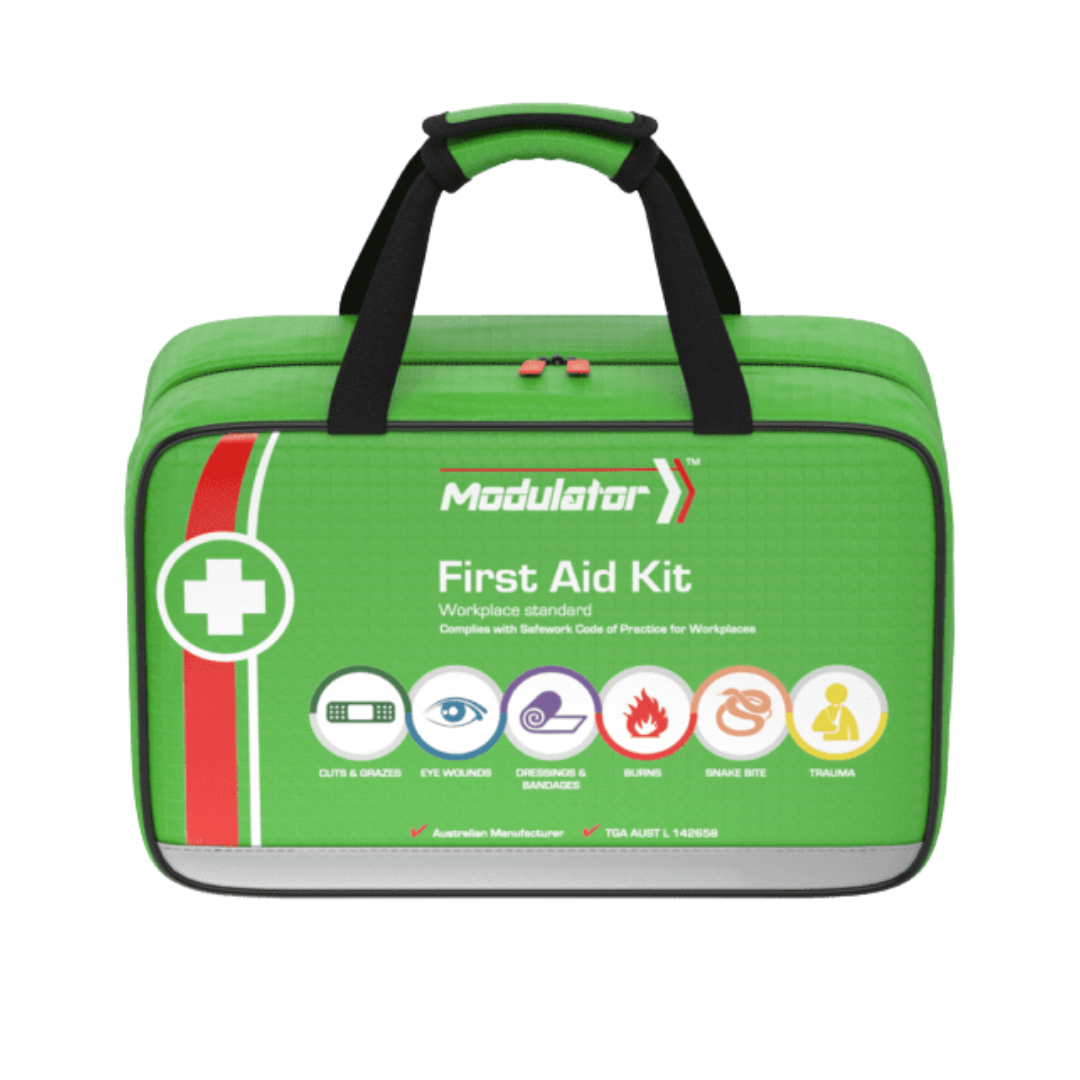 A close-up of the bright green Modulator Softpack First Aid Kit (Workplace Standard). It has a red and white stripe, black carry handles, and lists the six color-coded modules with icons: Cuts & Grazes, Eye Wounds, Dressings & Bandages, Burns, Snake Bite, and Trauma. It is TGA compliant.