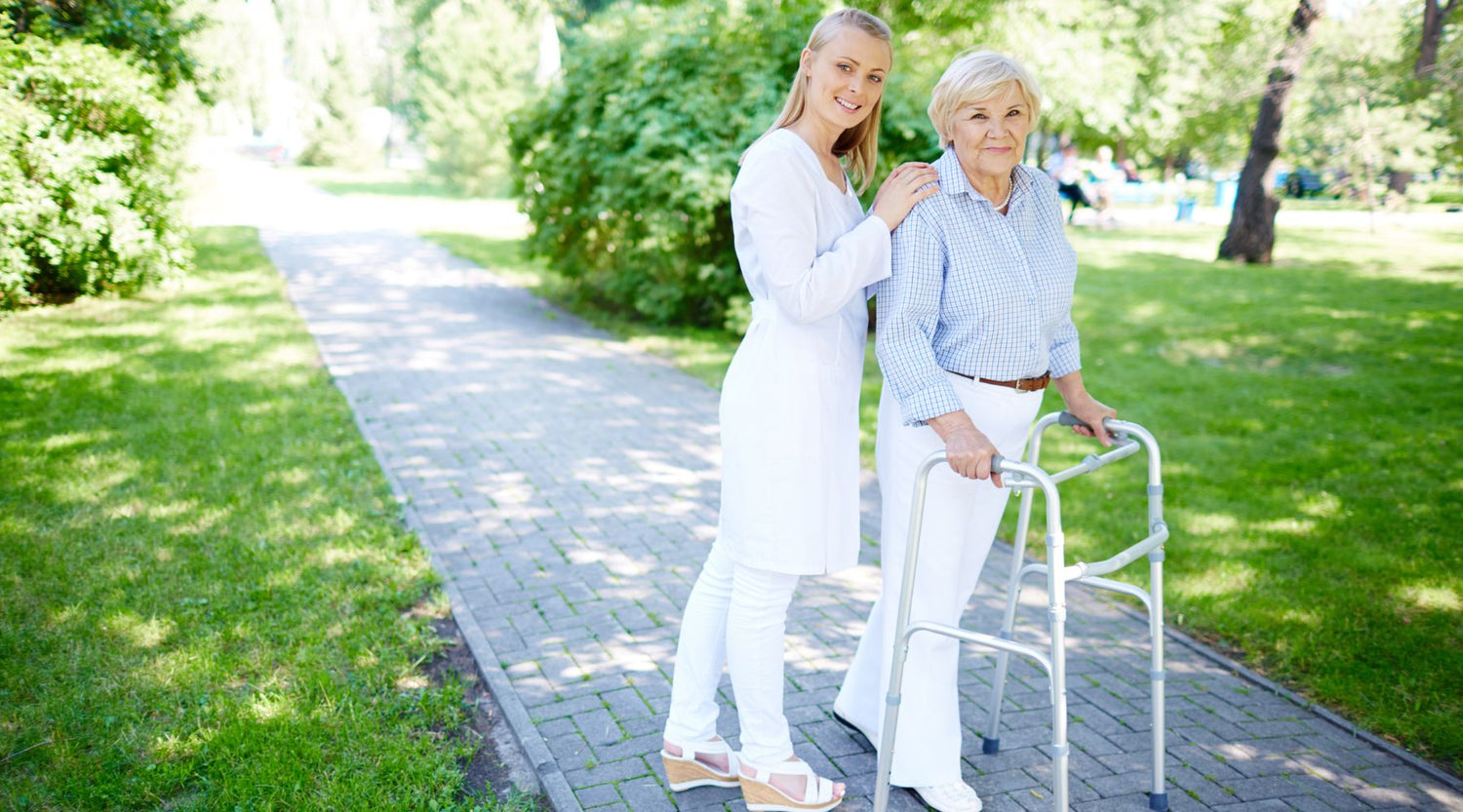 nurse-helping-senior-woman-use-walking-frame