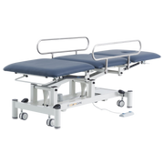 Three Section Medical Treatment Couch with Side Rails in Navy Blue, shown in a fully flat position with metal safety rails raised and white electric lift frame.