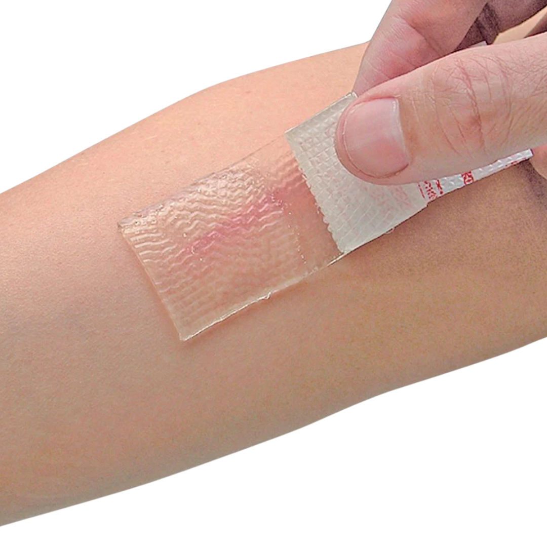 Close-up of a hand applying a transparent Cica-Care Silicone Gel Sheet to a linear scar on a person's arm to demonstrate ease of use.
