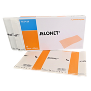 A box of Smith & Nephew JELONET paraffin gauze dressings (size 10cm x 40cm) displayed with several individual sterile foil pouches and a large unfolded sachet.