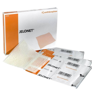 A white and orange box of Jelonet Paraffin Gauze Dressings, with two individually packaged, sterile dressings stacked in front of it. The gauze material is visible on top.