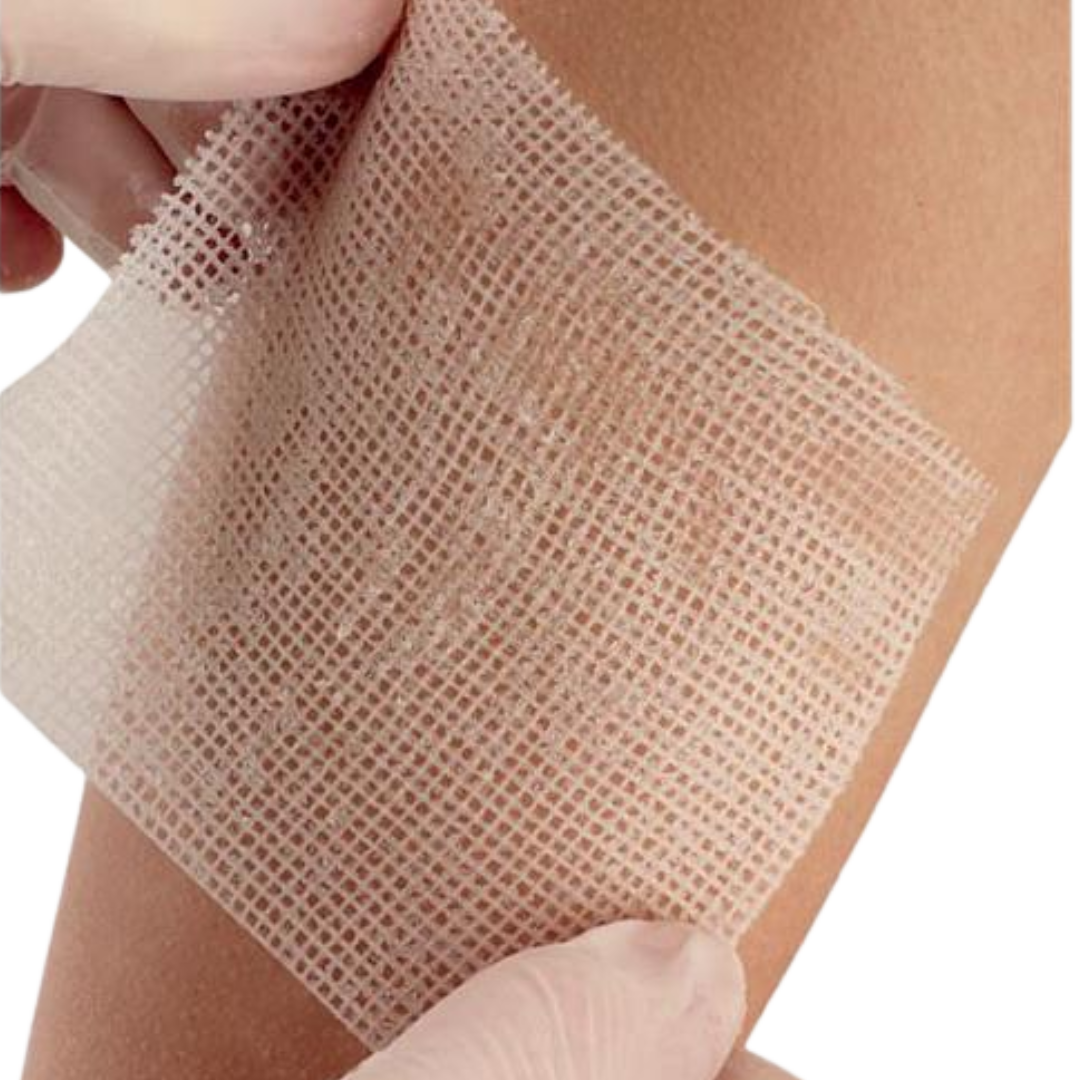 A gloved hand applying a piece of Jelonet Paraffin Gauze Dressing to a person's skin, demonstrating the soft, open-weave mesh material.