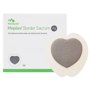 A Mepilex Border Sacrum Ag antimicrobial dressing placed next to its original white and green packaging.
