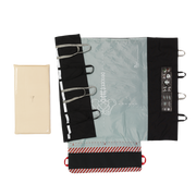 A flat lay view of the Mölnlycke Tortoise Turning and Positioning System, showing the light blue positioning mat with spinal alignment graphics, black reinforced handles, and a cream-colored foam pressure-redistribution pad.