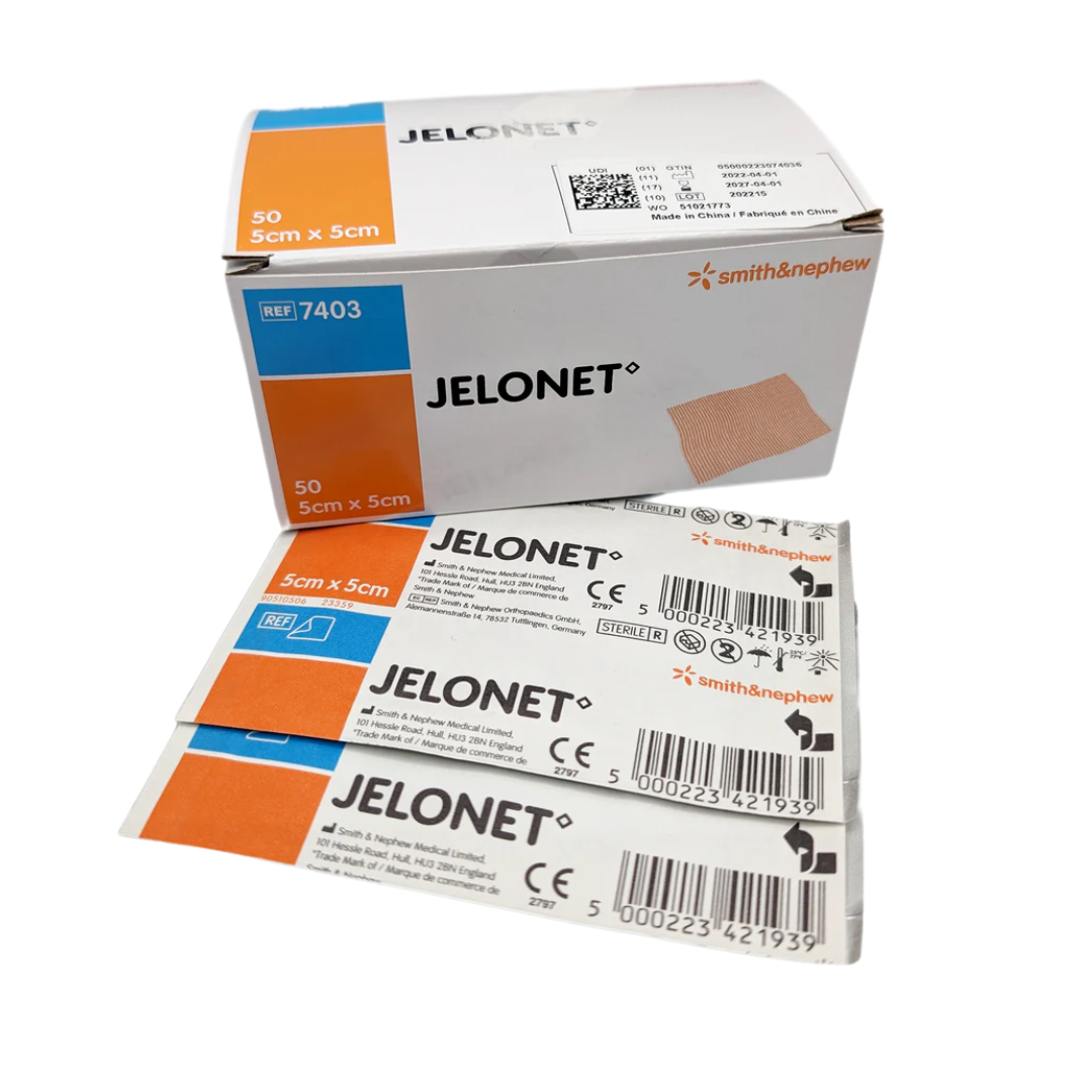 Box of Jelonet Paraffin Gauze Dressing ($5 \times 5 \text{ cm}$) resting on top of several individual sterile sachets of the product.